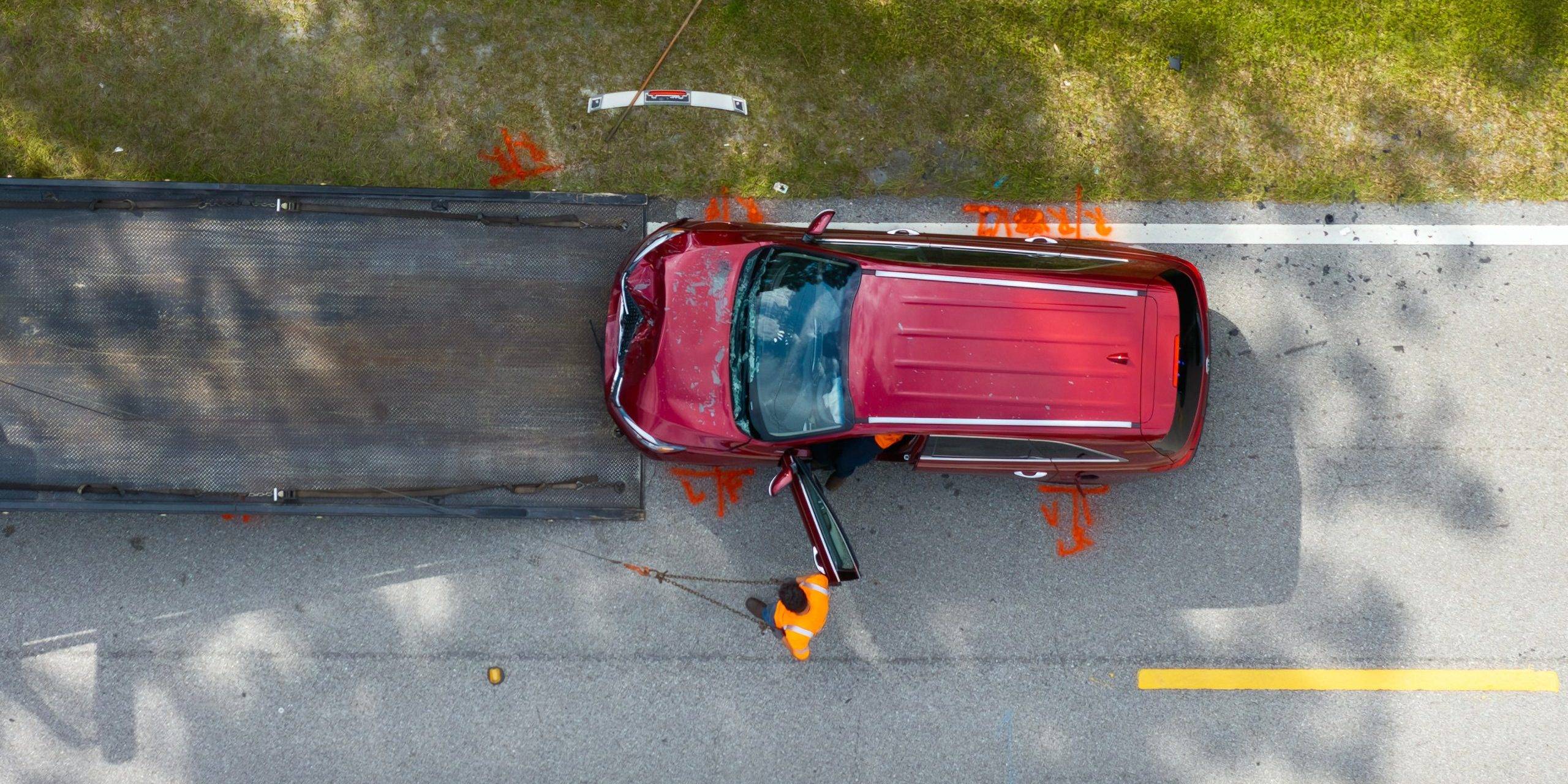 Car Crash Site With Tow Truck Loading Destroyed Vehicle On American Street. Emergency Services Personnel Responding To Accident In Florida, Usa